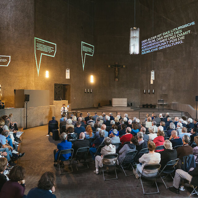 Volle Kirche: St. Gertrud bei der Ausstellungseröffnung von "Fluch und Segen. Kirchen der Moderne".
